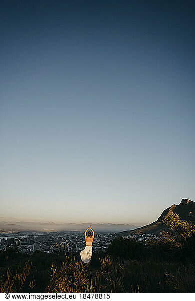 Woman practicing yoga on Signal Hill at sunset