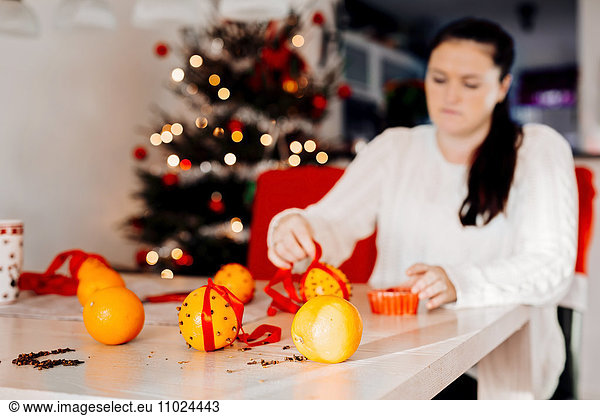 Woman preparing Christmas decorations at table
