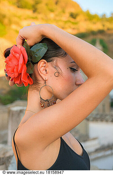 Woman puts a red flower in her hair