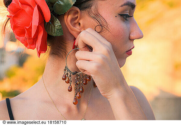 Woman puts an earring in her ear. Flamenco style