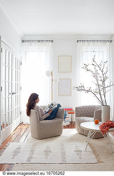 Woman reading in light-filled living space