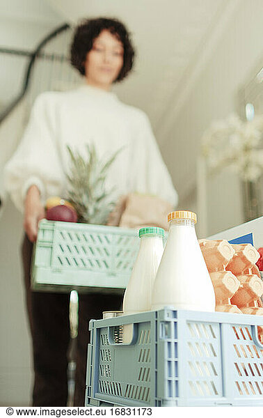 Woman receiving grocery delivery at home