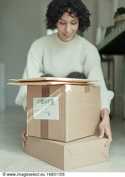 Woman receiving packages stacked on floor