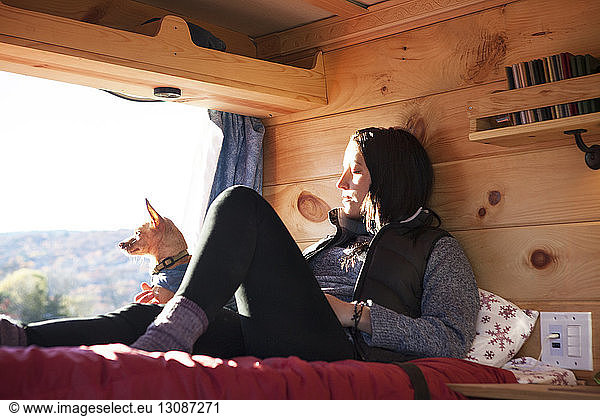 Woman relaxing on bed in camper van
