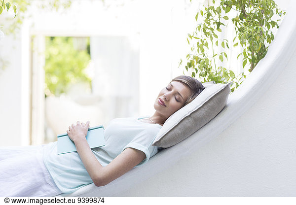 Woman relaxing on pillow outdoors