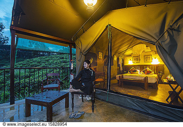 woman relaxing outside of luxury tent at lodge in Sri Lanka
