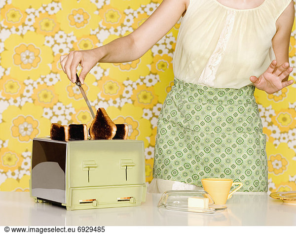 Woman Removing Burnt Toast from Toaster