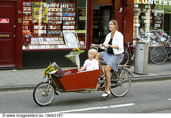 Woman riding a bicycle with her daughter. Amsterdam  Holland.
