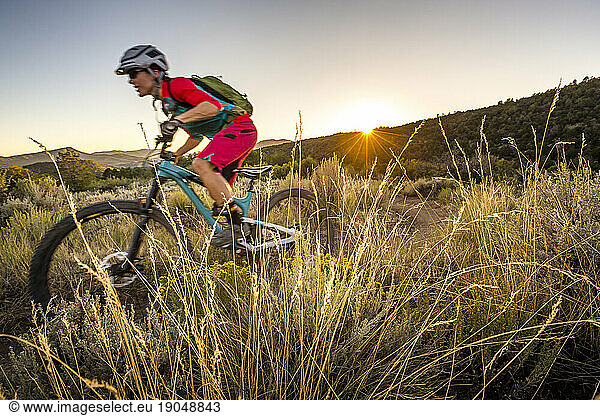 Woman riding a mountain bike at sunset.
