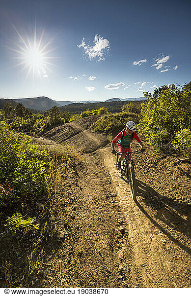 Woman riding a mountain bike outdoors on a sunny day.