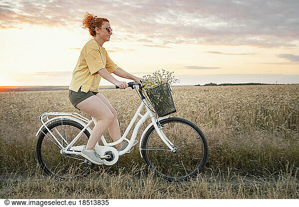 Woman riding bicycle in field