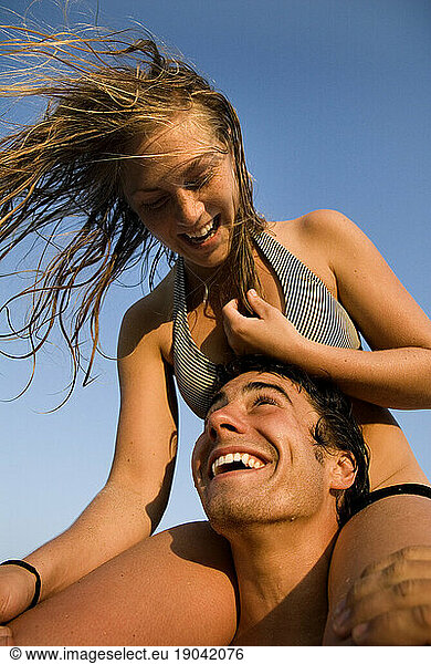 Woman riding on shoulders of a smiling man.