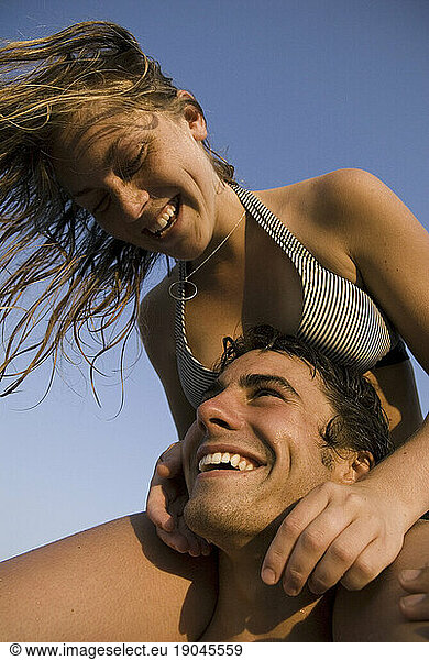Woman riding on shoulders of a smiling man.