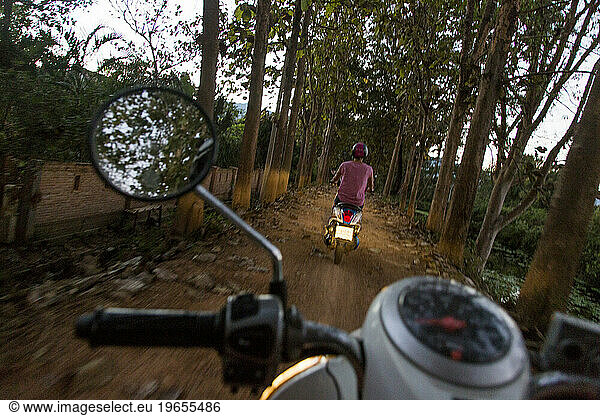 Woman riding scooter on dirt road  Pai  Mae Hong Soon  Thailand