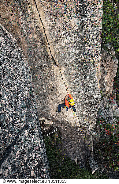 Woman rock climbing on vertical crack on rock face