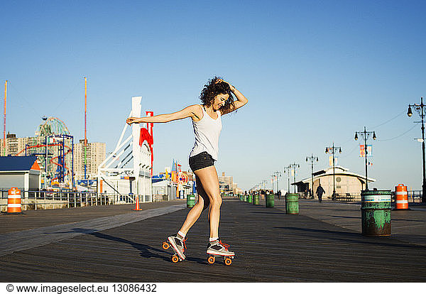 Woman rollerskating on promenade