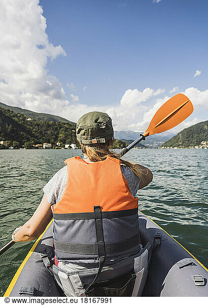 Woman rowing kayak on lake