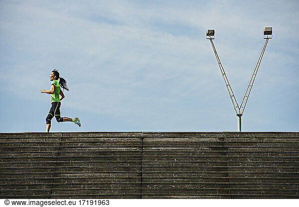 Woman running along wooden stairs in Paris