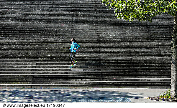 Woman running down wooden stairs in Paris