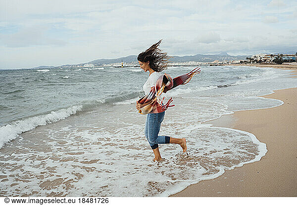 Woman running near waves at beach