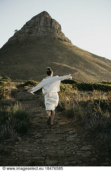 Woman running towards Lion's Head mountain at sunset