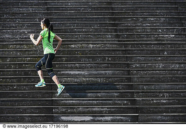 Woman running up wooden stairs in Paris