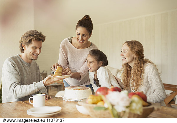 Woman serving cake to family at dining table