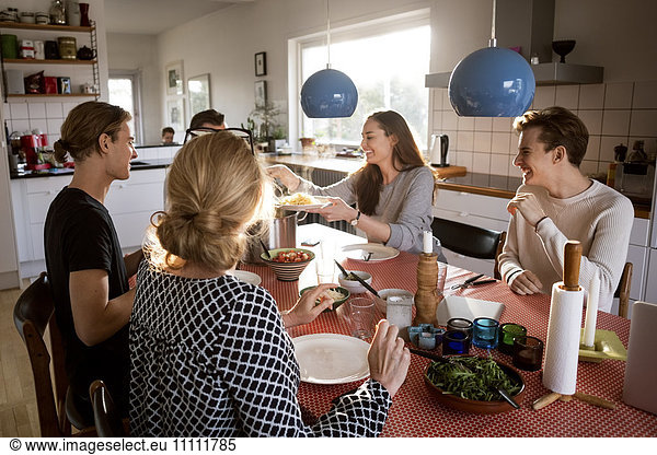 Woman serving food for family at dining table