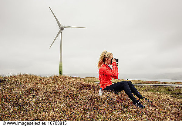 Woman shooting nature near windmill