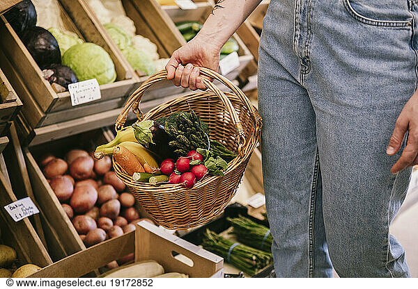 Woman shopping for fresh vegetables in supermarket