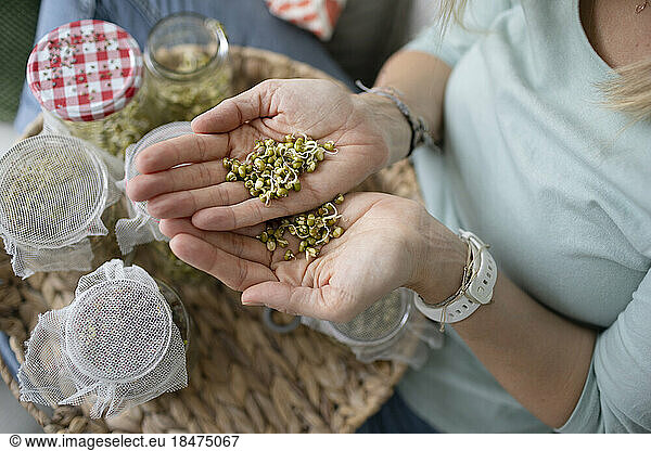 Woman showing bean sprouts at home