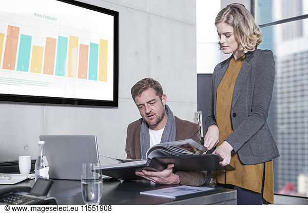 Woman showing folder to colleague in office
