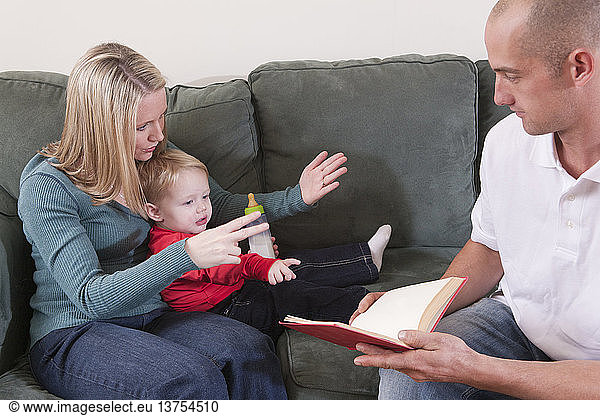 Woman signing the word ´Read´ in American Sign Language while teaching her son