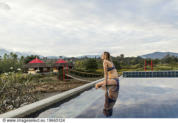 Woman sitting at edge of outdoor swimming pool  Pai  Mae Hong Soon  Thailand