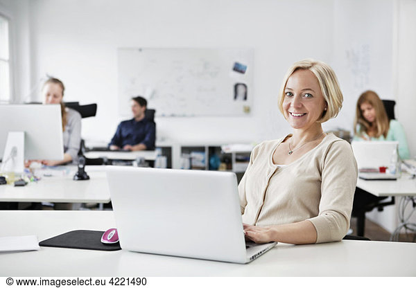 Woman sitting by computer at work