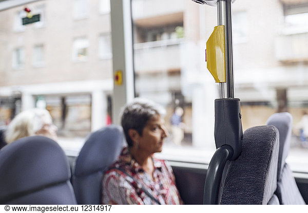 Woman sitting in bus and looking through window