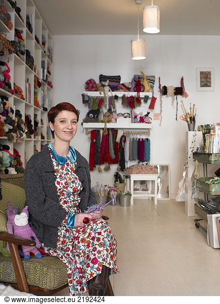 Woman sitting in craft shop  smiling  portrait