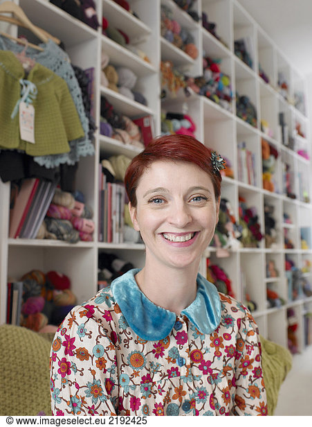 Woman sitting in craft shop  smiling  portrait  close-up