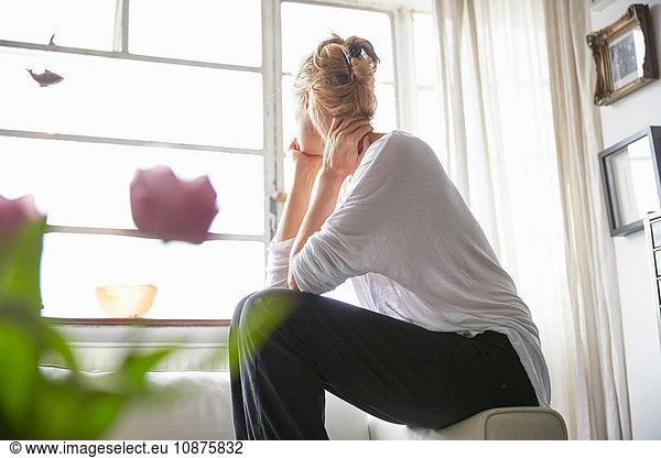 Woman sitting in front of window looking out