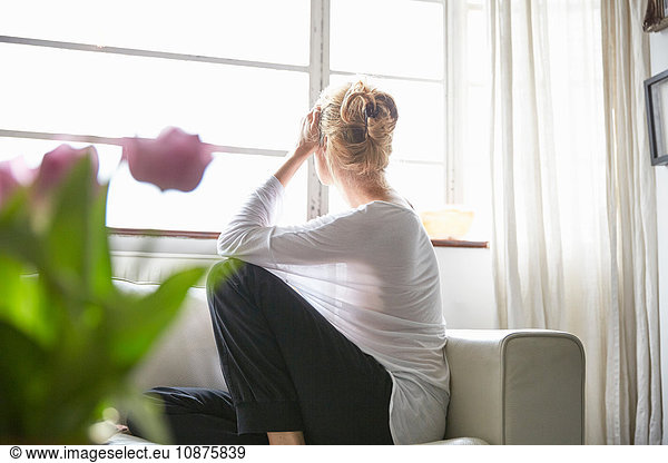 Woman sitting in front of window looking out