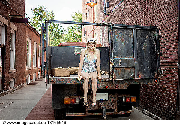 Woman sitting on a farmer's organic food truck outside grocery store