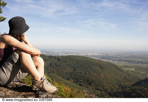 Woman sitting on mountain top