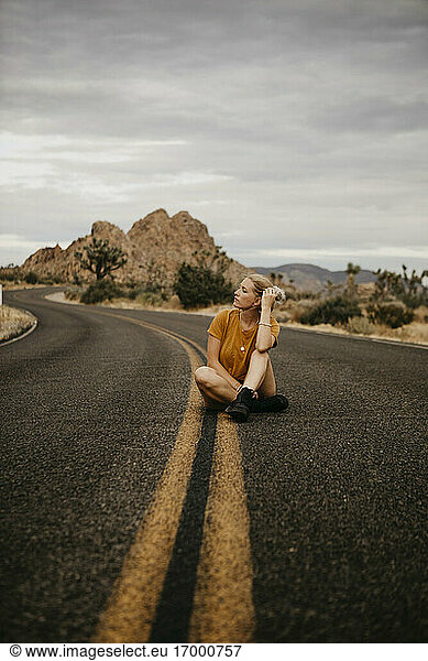 Woman sitting on road  Joshua Tree National Park  California  USA