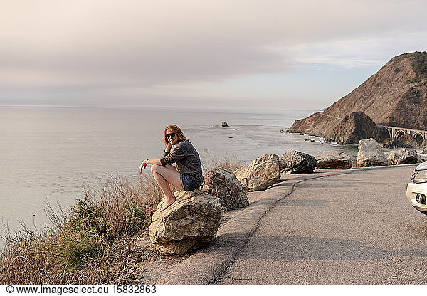 Woman sitting on rock at Big Sur View point