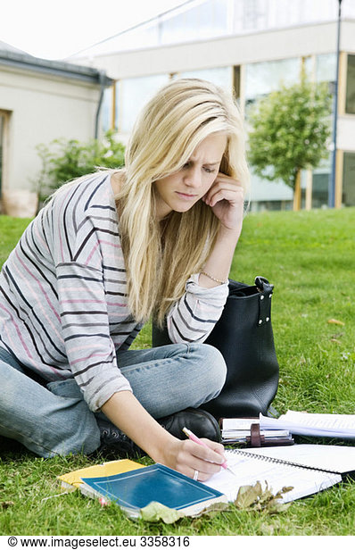 Woman sitting outside writing in notepad