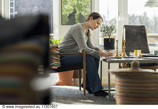 Woman sitting with document at home