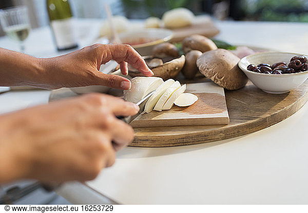 Woman slicing cheese on cutting board