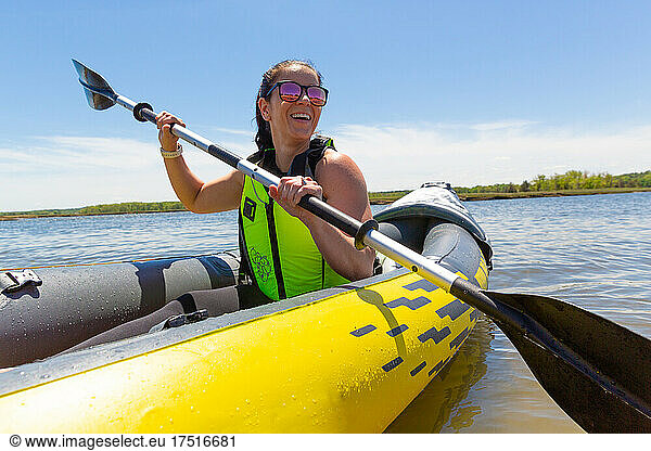 Woman Smiles while Paddling in Kayak on Ocean in New England