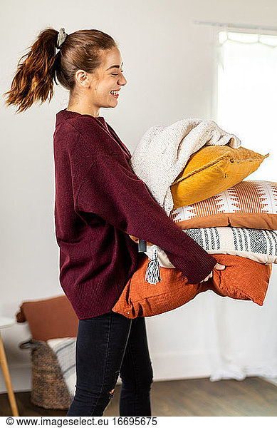 Woman Smiling Carrying Pillows and Smiling