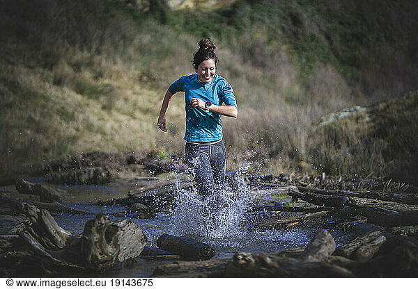 Woman splashing water running in sea